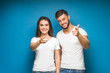 © Тарас Нагирняк - Pretty, young happy couple love smiling point finger to empty copy space, man and woman smile looking up, isolated over background