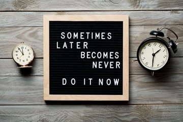 Sticker - Inspirational motivational quote Sometimes later becomes never. Do it now words on a letter board on wooden background near vintage alarm clocks. Success and motivation concept.