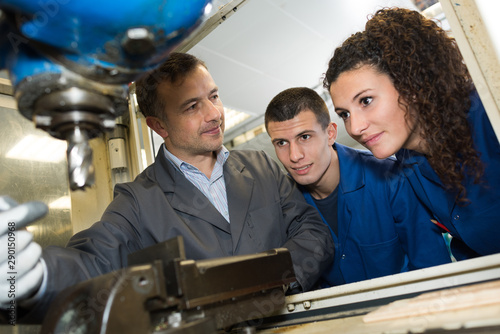 Fotomural engineer training male apprentice on milling machine