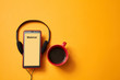 E-learning or online education concept. Webinar, internet lesson or courses. Headphones, coffee cup on yellow background
