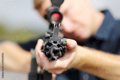 Cuadros en Lienzo Closeup of a man aiming an assault rifle with scope.