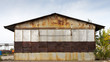 © Виталий Сова - Old brown warehouse with sheet metal cladding with street lights. Industrial concept of transportation, loading and storage of goods