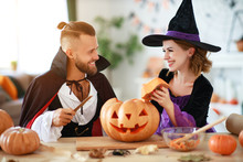 Couple Of People Are Preparing For Halloween In Costumes Of Witch And Vampire With Pumpkins.