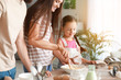 © Pixel-Shot - Little girl with parents cooking in kitchen