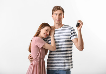 Poster - Happy young couple with key from new car on white background