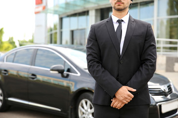 Professional bodyguard near car outdoors