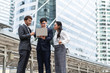 © ronnachaipark - group of asian business people working and discussing something positive with his mature colleague and using a laptop at outdoor in the capital