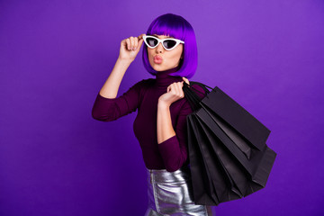 Sticker - Beautiful stylish lady holding many packs in hands send air kiss dressed in trendy outfit isolated purple background