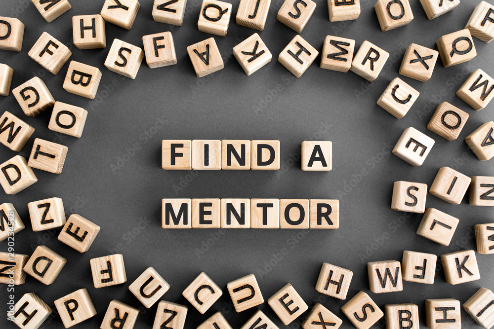 Find a mentor - phrase from wooden blocks with letters, Online mentorship a voluntary counselor or teacher concept, random letters around, grey background - obrazy, fototapety, plakaty 