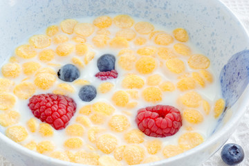 Wall Mural - Bowl of cornflakes and berries in milk