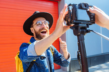 social media influencer creating content. man shooting video of himself using camera on tripod. smiling bearded hipster guy communicating with subscribers.