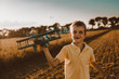 © cherryandbees - cute little boy playing outdoor with wooden airplane toy