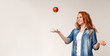 Beautiful redhead girl throwing apple in the air