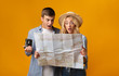 Young couple of travellers holding map being shocked