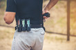The gun magazine at the man's waist is ready to be used with his sparkling pistol.