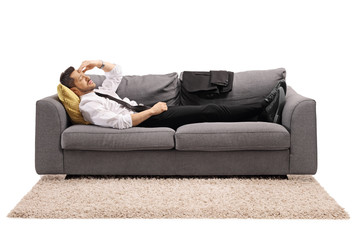 Canvas Print - Businessman resting on a sofa bed after work