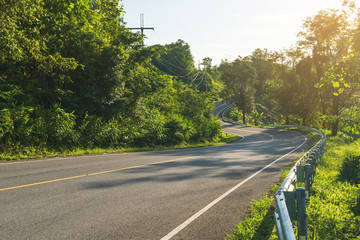 Uphill road with a curve with sunlight