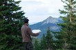 © AlexR - hiker man in cap with map in front of mountain range in the carpathian mountains gorgany