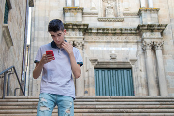 Sticker - young teenage man with mobile phone walking in the city