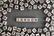 Jargon  - word from wooden blocks with letters,  special words and phrases jargon concept, random letters around, top view on grey background
