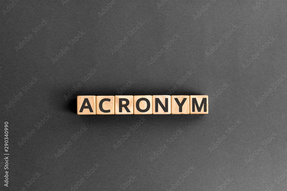 acronym - word from wooden blocks with letters, use of acronyms in the modern world abbreviation concept, random letters around, top view on wooden background - obrazy, fototapety, plakaty 