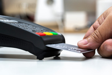 man hand with credit card swipe through terminal for payment, buy and sell products