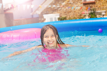 Wall Mural - Smiling cute little girl in small swimming pool