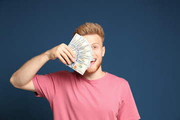 Wall Mural - Portrait of happy lottery winner with money fan on blue background