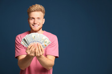 Wall Mural - Portrait of happy lottery winner with money fan on blue background