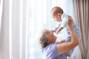 Wall Mural - Happy grandmother with little baby at home