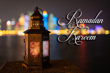 Wall Mural - Vintage lantern. Ramadan Kareem mood at night with light of Doha city in the background.