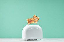 Roasted Toast Bread Popping Up Of Toaster With Green Wall, Front View
