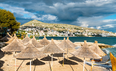 Wall Mural - Straw umbrellas on a beach in Saranda, Albania