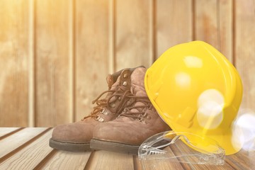 Wall Mural - Yellow working hard hat, goggles and work boots on  background