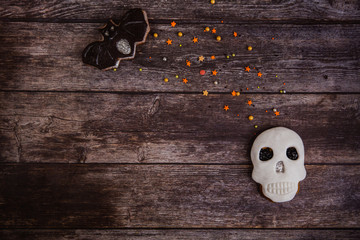 Sticker - Hand painted gingerbread cookie scary Halloween skull with colored sprinkles on wooden background. Top view