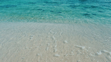 Emerald green water. Beautiful background transparent surface wave, sand on clean beach. Royalty high-quality free stock photo image of clean surface seawater, waves on the beach with sand in sunshine