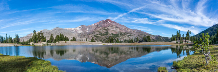 Wall Mural - volcanic mountain in morning light reflected in calm waters of lake.