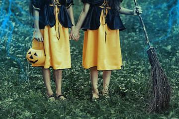 Two young witches in forest on Halloween