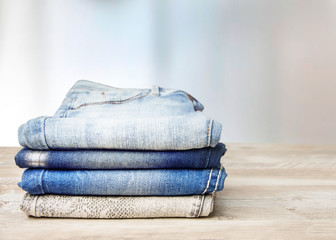 Wall Mural -  Pile of jeans on a wooden table