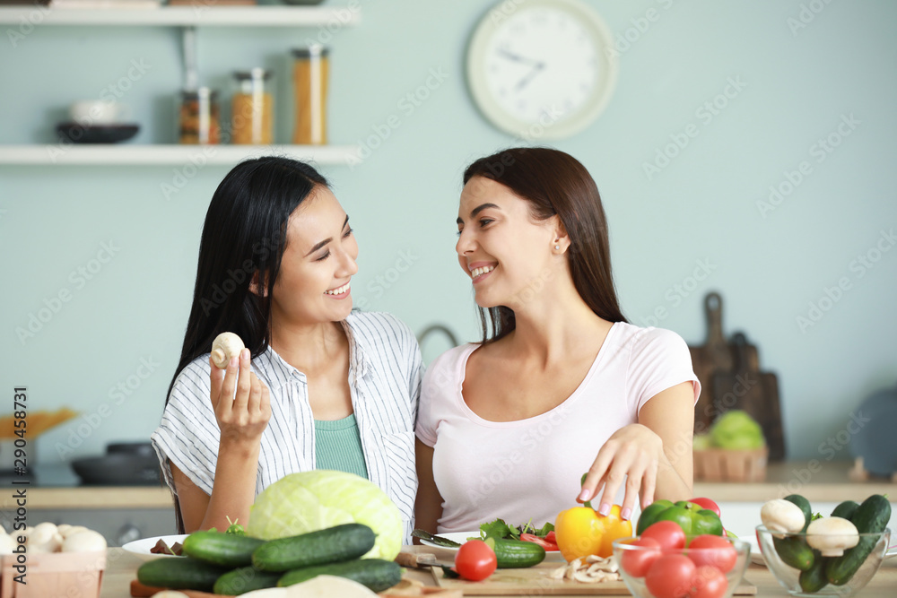 Beautiful women cooking together in kitchen