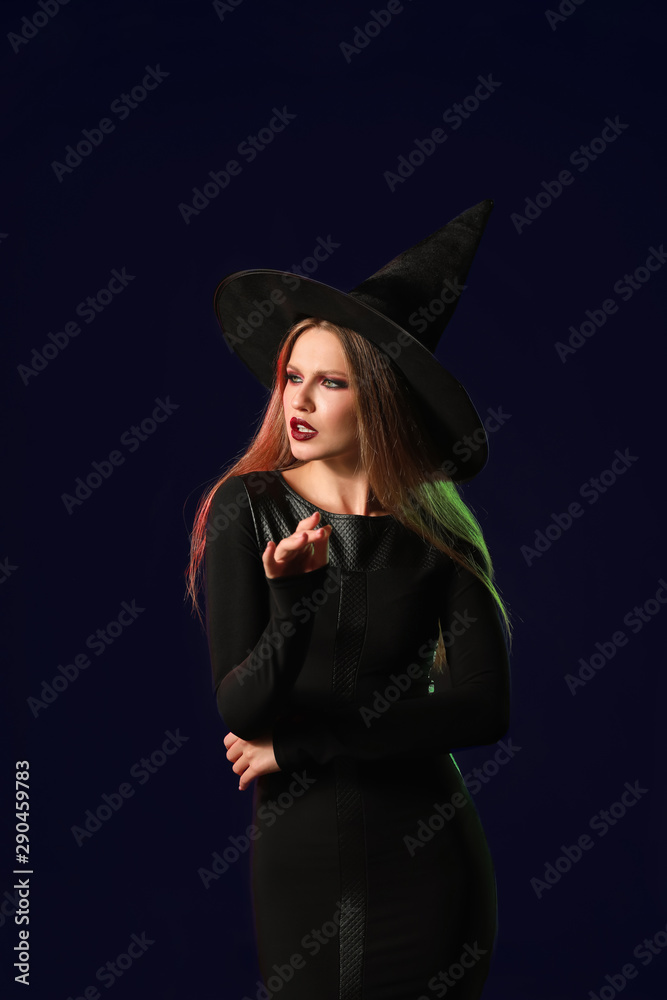 Beautiful woman dressed as witch for Halloween on dark background