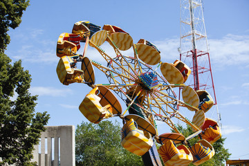 Wall Mural - Yellow carousel in a summer city park.