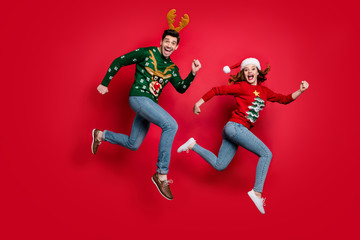 Poster - Full length photo of crazy jumping couple excited by x-mas discounts prices wear ugly ornament jumpers isolated red color background