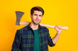 Photo of criminal guy looking without smile on enemy ready to use big ax wear casual plaid shirt isolated yellow color background