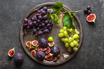Wall Mural - Fresh fruits on plate. Assorted grape and purple figs. Healthy food, vegan diet concept.