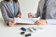© Orathai - Car dealership provides advice about insurance details and car rental information and delivers the keys after signing the rental contract