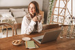 © Drobot Dean - Ginger business woman sit indoors in office drinking coffee.