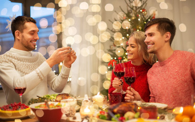 Poster - holidays and celebration concept - happy friends photographing at christmas dinner