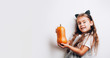 © paninastock - Scary little girl holding decorative pumpkins on white background.