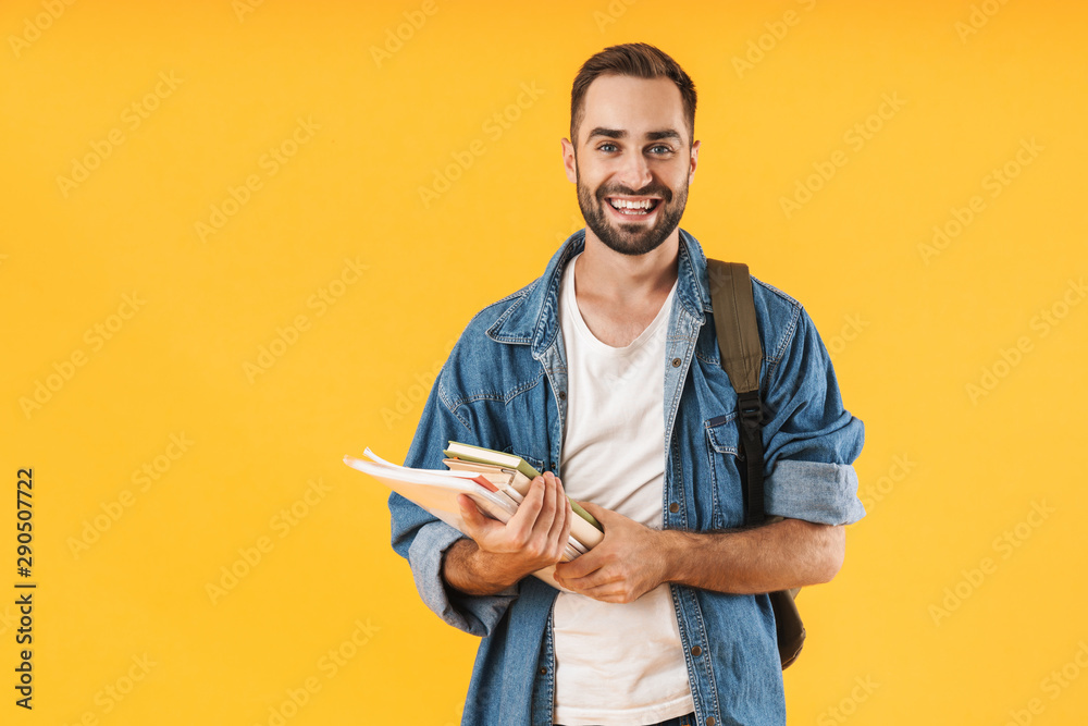 Image of content student guy smiling while holding exercise books - obrazy, fototapety, plakaty 